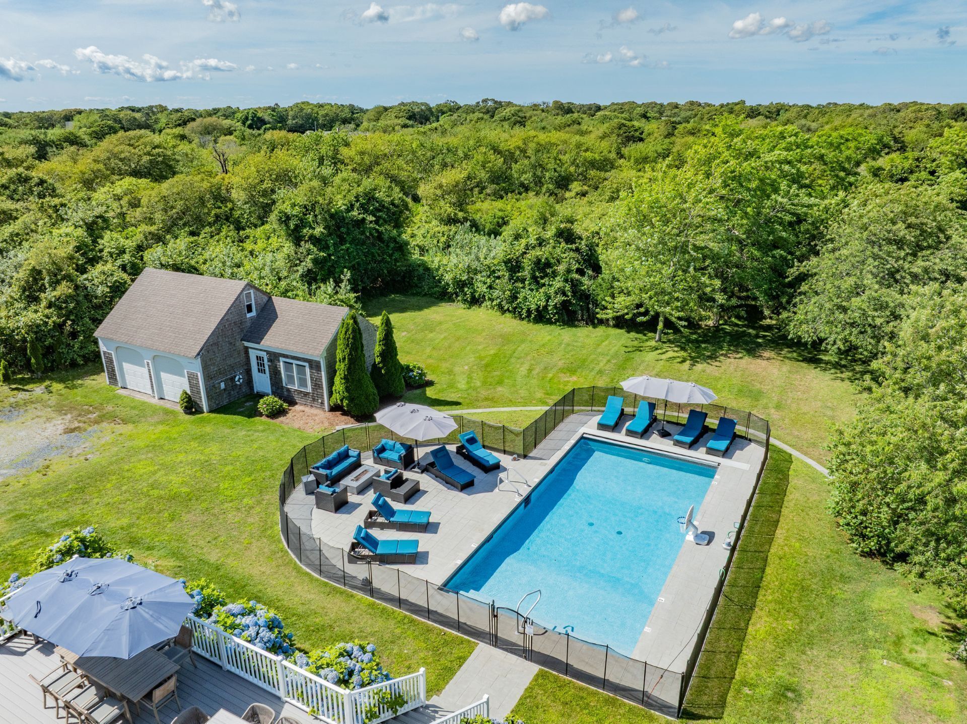 En boligejendom med swimmingpool, udendørs siddepladser og et hus.