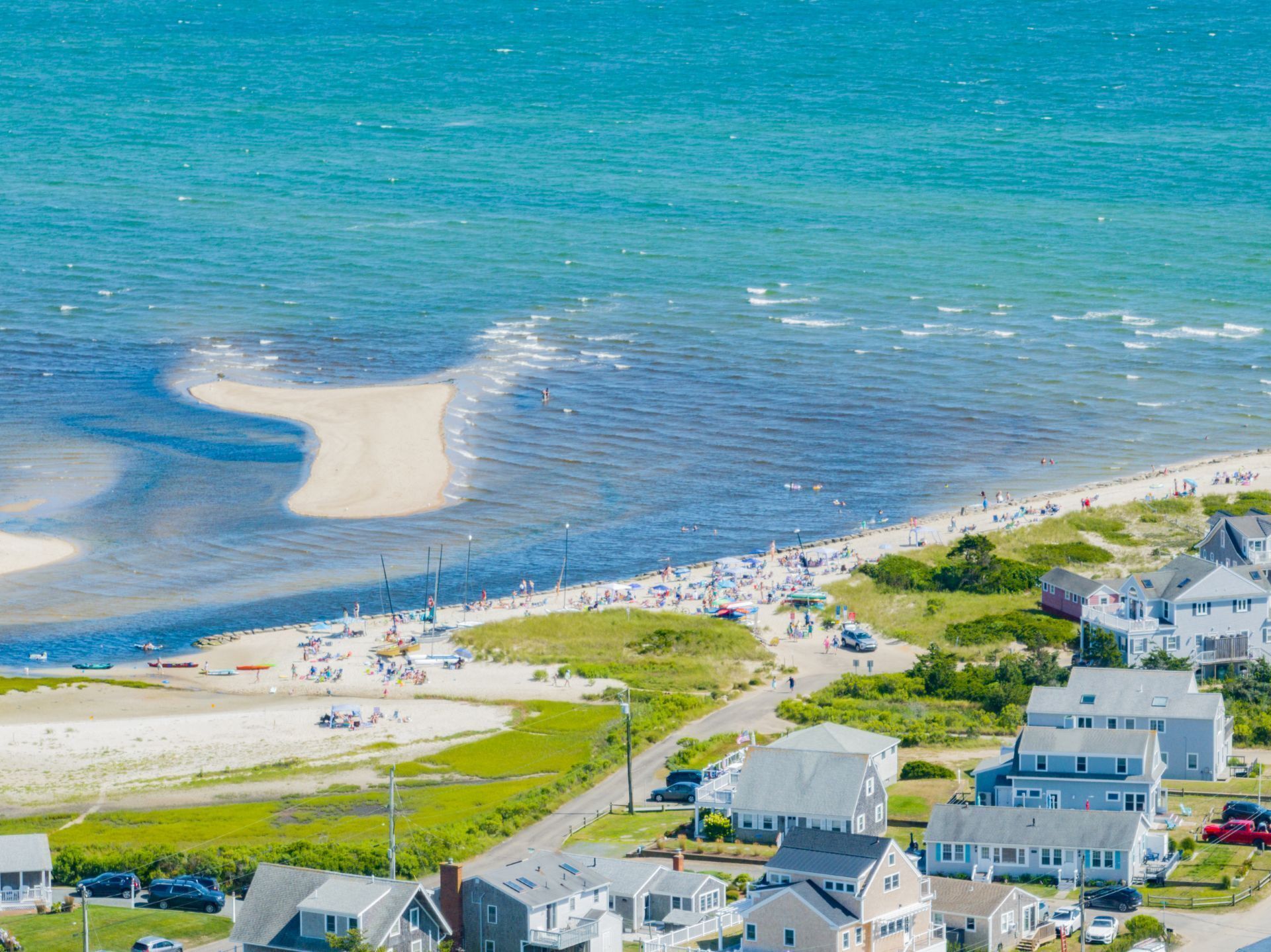 A coastal town with a sandy beach, houses, and boats.