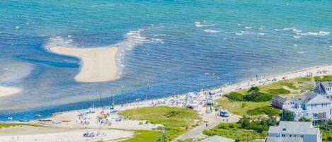 A coastal town with a sandy beach, houses, and boats.