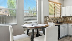 A kitchen with white cabinets, a wooden countertop, and a round dining table with chairs. - Charming 2-bedroom townhome near ASU in Tempe  with AC, garage, and a pool! (Tempe)