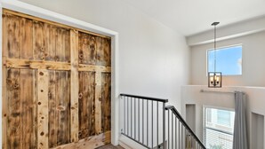 A staircase with a wooden door at the top, a metal railing, and a window with blinds. - Charming 2-bedroom townhome near ASU in Tempe  with AC, garage, and a pool! (Tempe)