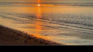 A beach scene with a sunset over the ocean. - 20 minutes to Blue Mountain / games room (Wasaga Beach)
