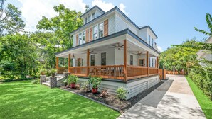 Une maison à deux étages avec un porche abrité et une pelouse bien entretenue.