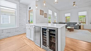 Une cuisine moderne dotée d’appareils électroménagers en acier inoxydable, d’un plan de travail blanc et d’un réfrigérateur encastré.