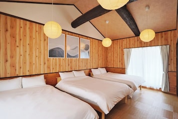 A bedroom on the 2nd floor with high ceilings, 3 double beds, and a closet