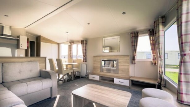 Ein modernes Wohnmobil-Interieur mit einer Sitzecke, einem Esstisch und einem Kamin.