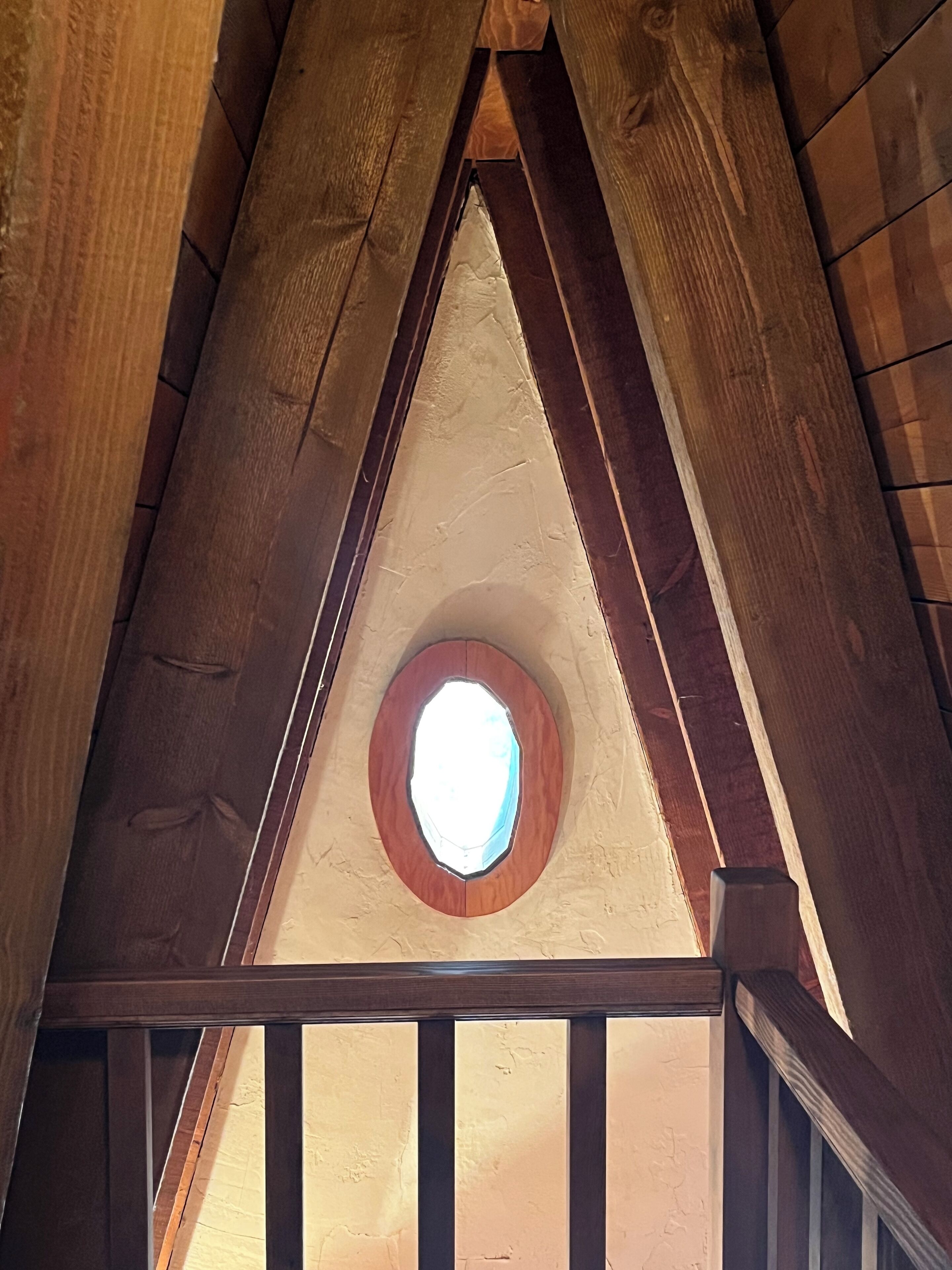 Un plafond triangulaire en bois avec une lucarne.