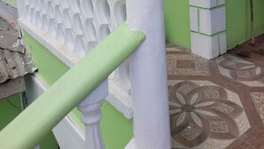 A staircase with white balusters and a green wall. - J and N Cozy Quarters (Roseau)