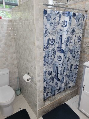 Een douche, handdoeken, zeep, toiletpapier