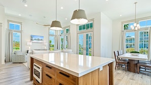 A spacious kitchen with a large island, wooden cabinetry, and pendant lighting.