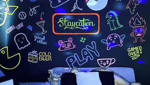 A room with a neon sign reading "Staycation" surrounded by various neon doodles and text. - Granite @ Shore Residences 2BR (Pasay City)