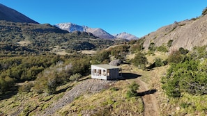 Una cabaña en zona montañosa con cielo despejado.