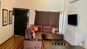 A furnished living room with a sofa, a table with papers, a TV, and a door. - JOY & PEACE HOUSE come to enjoy our brand new house . (Tela)