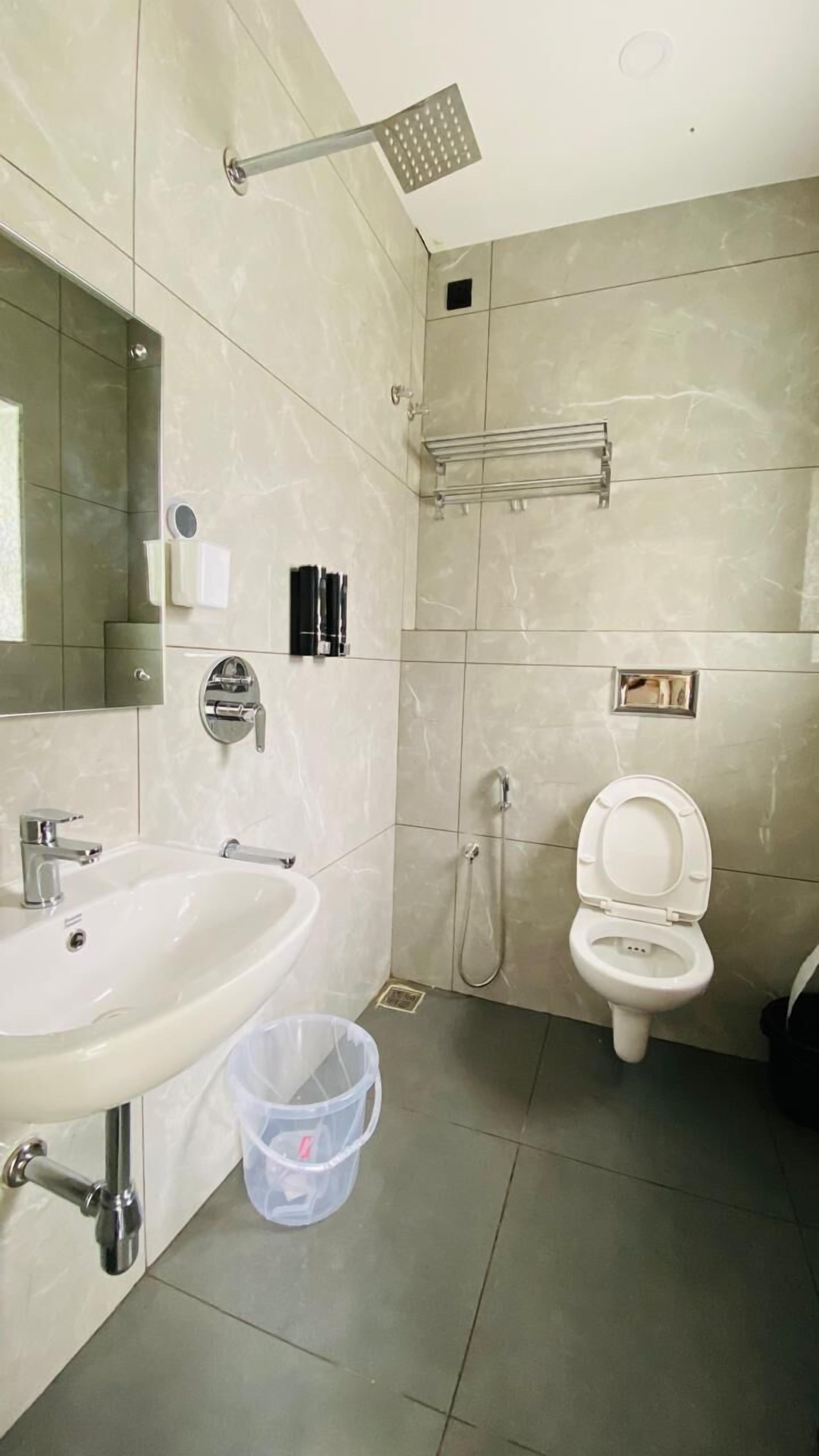 A modern bathroom with a sink, toilet, and shower.