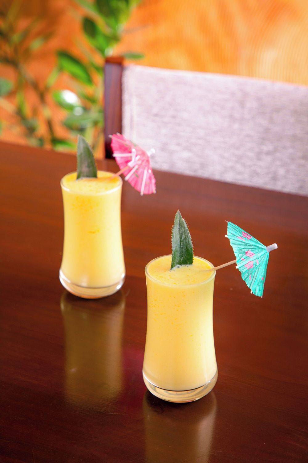 Dos bebidas sobre una mesa de madera con un fondo desenfocado.
