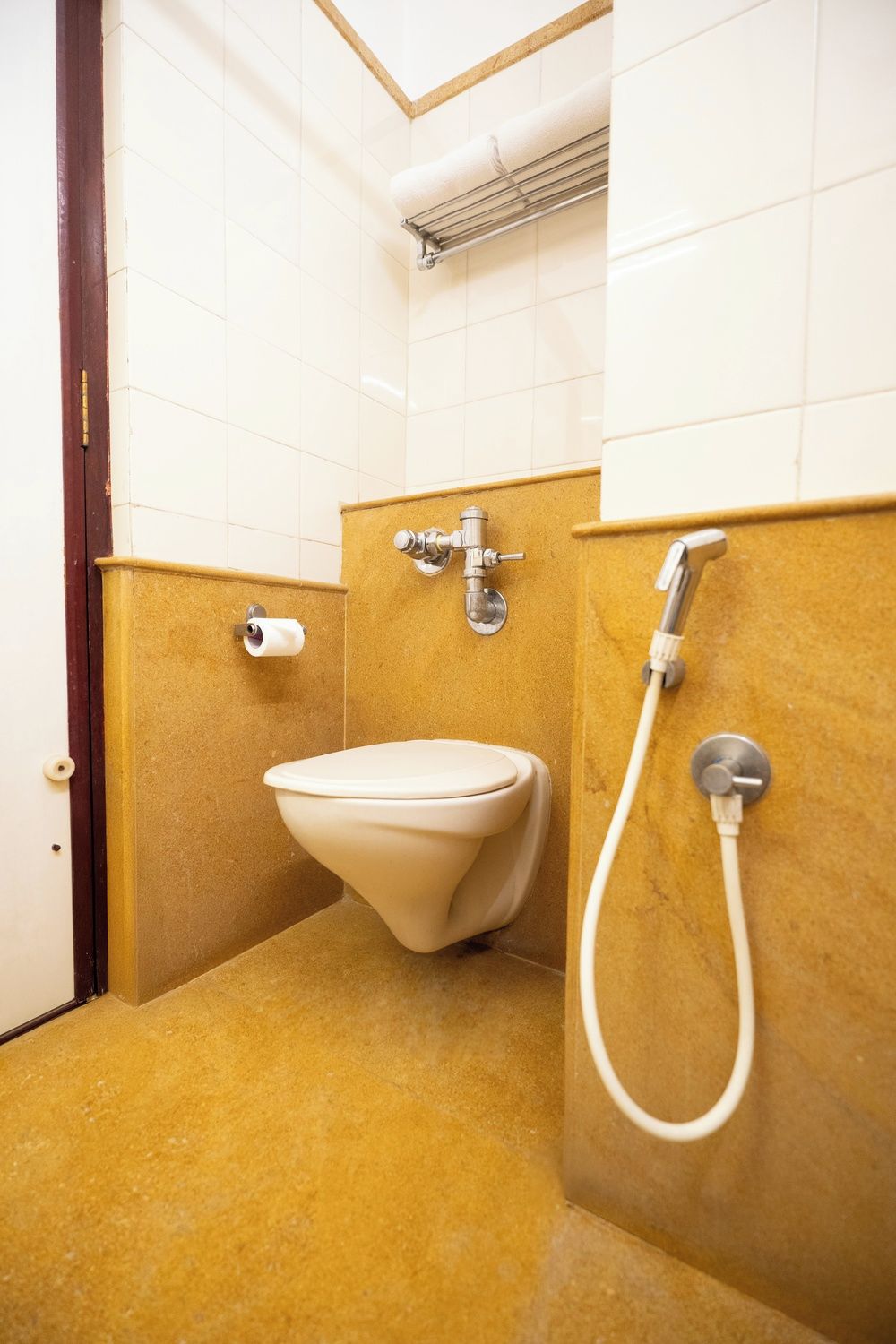 Un baño con inodoro, ducha y toallero.