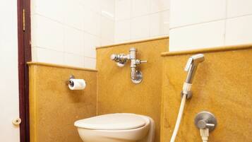 Un baño con inodoro, ducha y toallero.