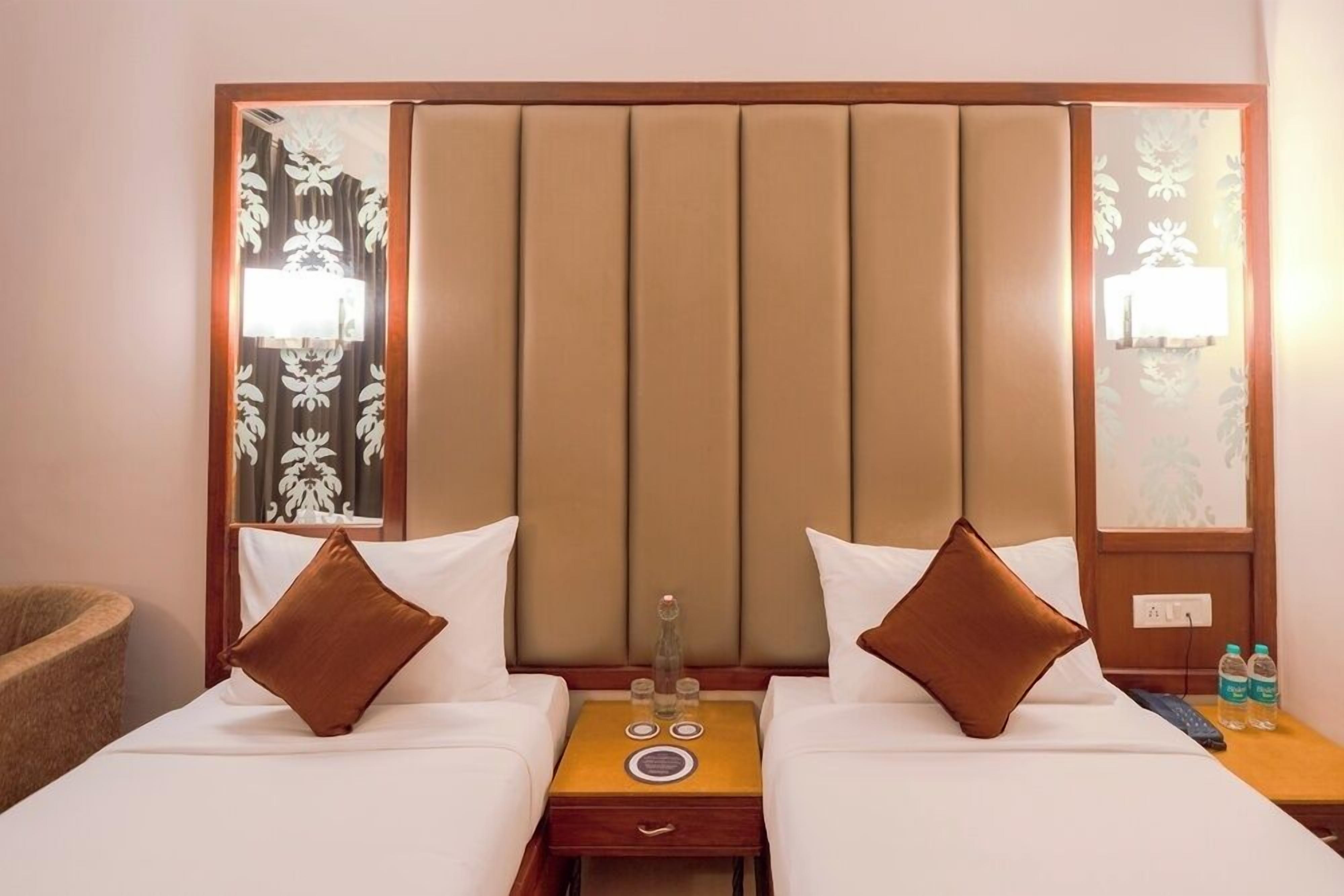 A hotel room with a large bed, two bedside tables, a mirror, and a nightstand.