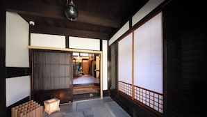 A traditional Japanese room with tatami flooring, sliding doors, and a low wooden bench. - The Tenpō | 220-Year-Old Kyoto Cultural Property with Garden & Sauna (Nishifudatsujicho, Higashikujyo, Minami-ku)