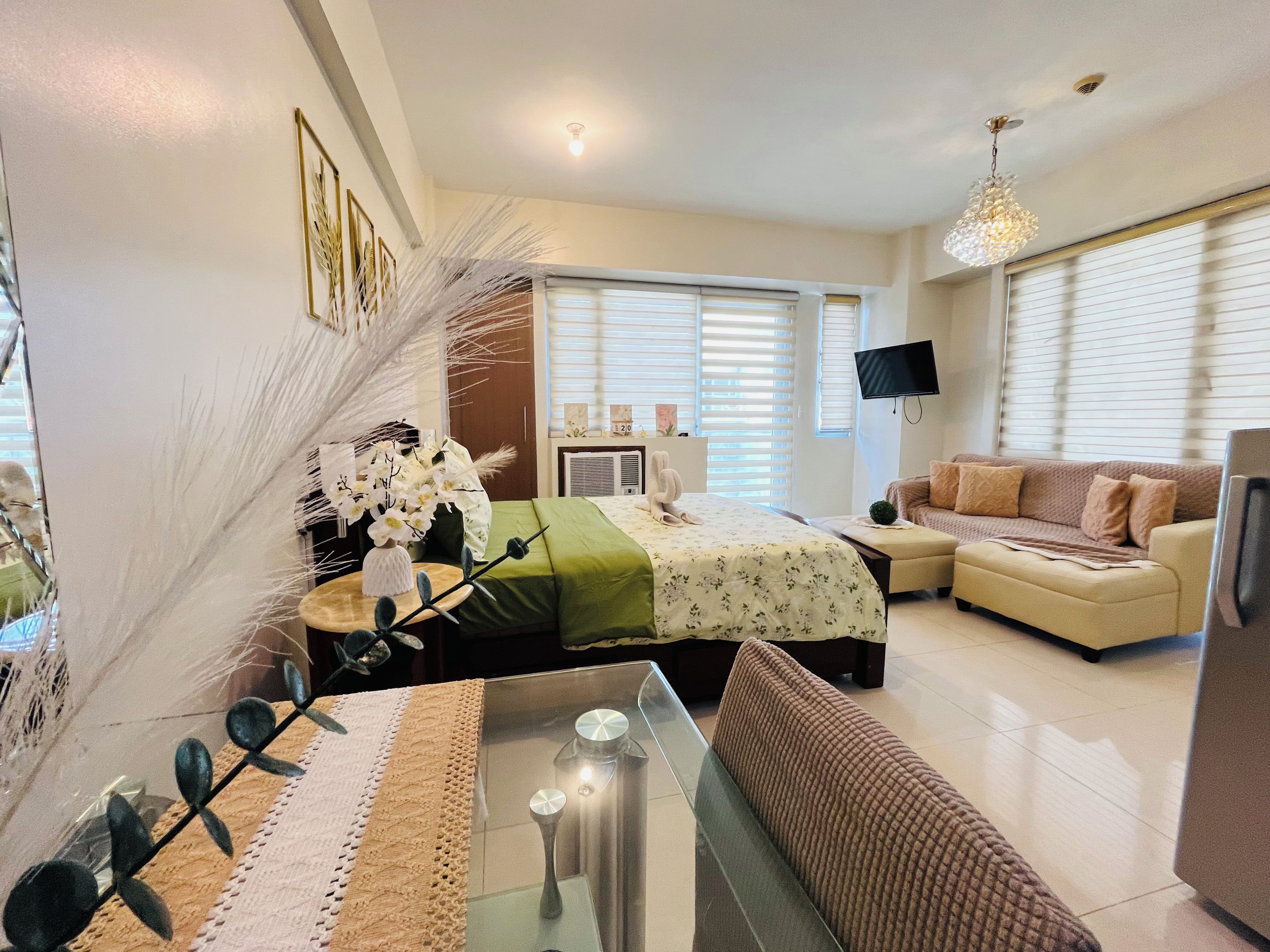 A modern living room with a sofa, a coffee table, and a TV mounted on the wall.