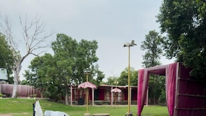 Una piscina rectangular con borde de piedra, rodeada de césped.