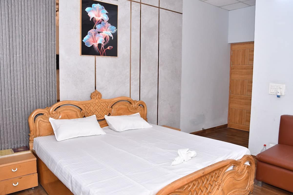 A neatly made bed with a wooden headboard, white bedding, and a single decorative pillow.