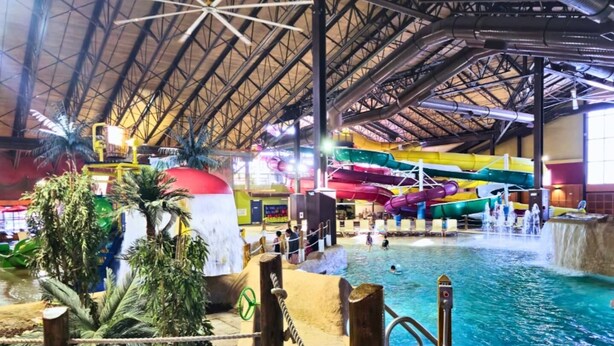 Ein großer Indoor-Wasserpark mit mehreren Rutschen und einem weitläufigen Poolbereich.