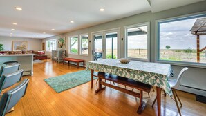 A spacious kitchen with a dining area, large windows, and a view of the outdoors. - Mtn-View Home w/ Pickleball Court in Louisville! (Louisville)