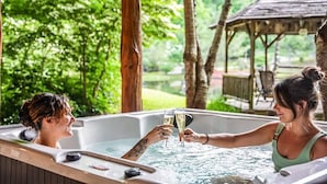 Ein Whirlpool mit zwei Personen, die mit Sektgläsern anstoßen.