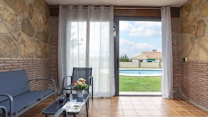 A balcony with a table, chairs, and a view of a swimming pool.