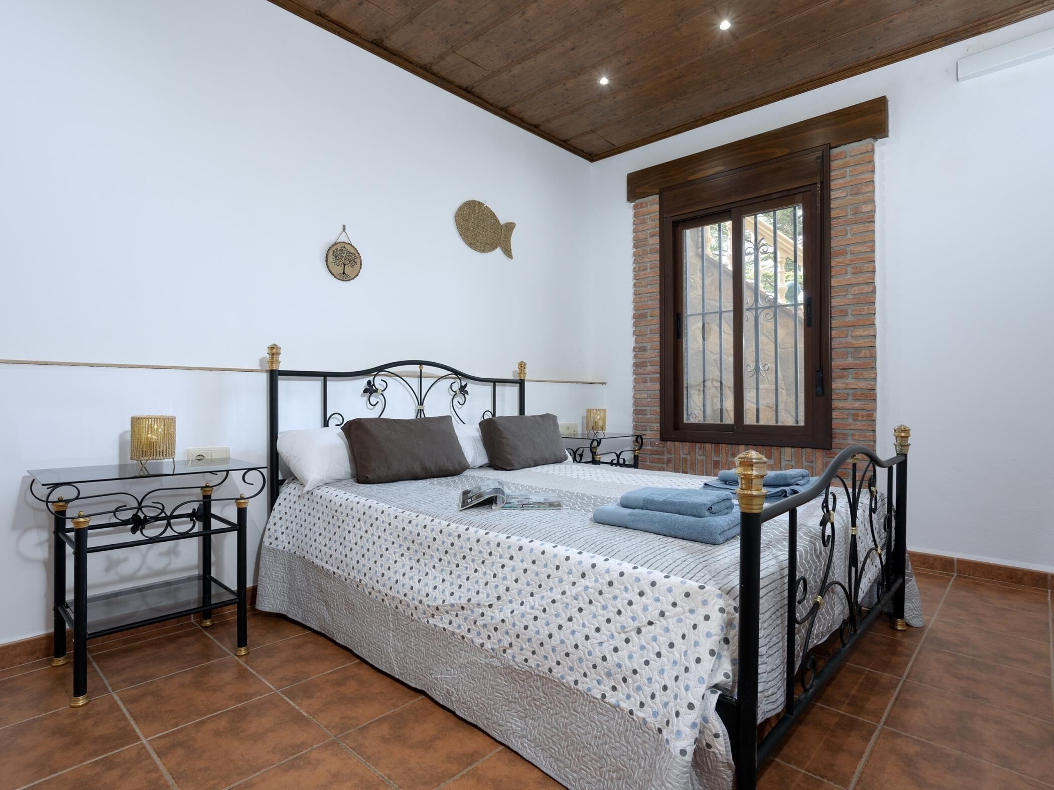Une chambre à coucher avec un lit, une table de chevet, une fenêtre et une horloge murale.