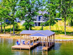 Une jetée au bord du lac, avec des chaises et un pavillon abrité.