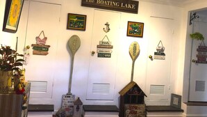 Ein Zimmer mit einem Schild, das "The BOATING LAKE" zeigt, verschiedenen Dekorationselementen und einer kleinen Holzkonstruktion, die einem Boot ähnelt.