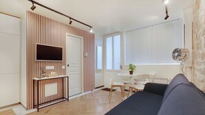 Un dormitorio moderno con cama, televisión, escritorio y silla.