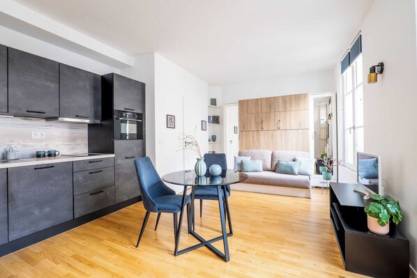 A modern apartment with a kitchen, dining area, and living room.
