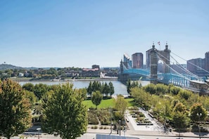 A suspension bridge with a clear view of the river and surrounding greenery. - TWO CozySuites at the Banks 17 (Cincinnati)