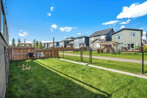 Zona residencial con casas, una terraza de madera y un patio cercado.