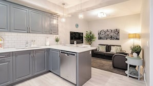 Une cuisine moderne avec des meubles gris, un lave-vaisselle et un îlot central.