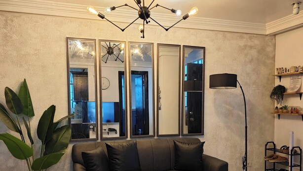 A living room with a sofa, coffee table, floor lamp, and a large mirror. - Escape to LuxHomme Your Spacious Sanctuary in the Heart of Baguio (Baguio)