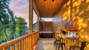 Eine Holzterrasse mit Whirlpool, Holzstühlen und einem Tisch mit Handtüchern.