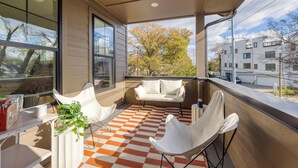 A balcony with a checkered floor, white furniture, and a plant. - 2 New Townhomes w/ Balcony, Mins to Broadway, Sleeps 16 | 98 Degrees & The Stage (Nashville)