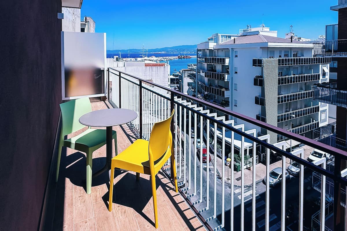 Un balcón con vista al mar y edificios.