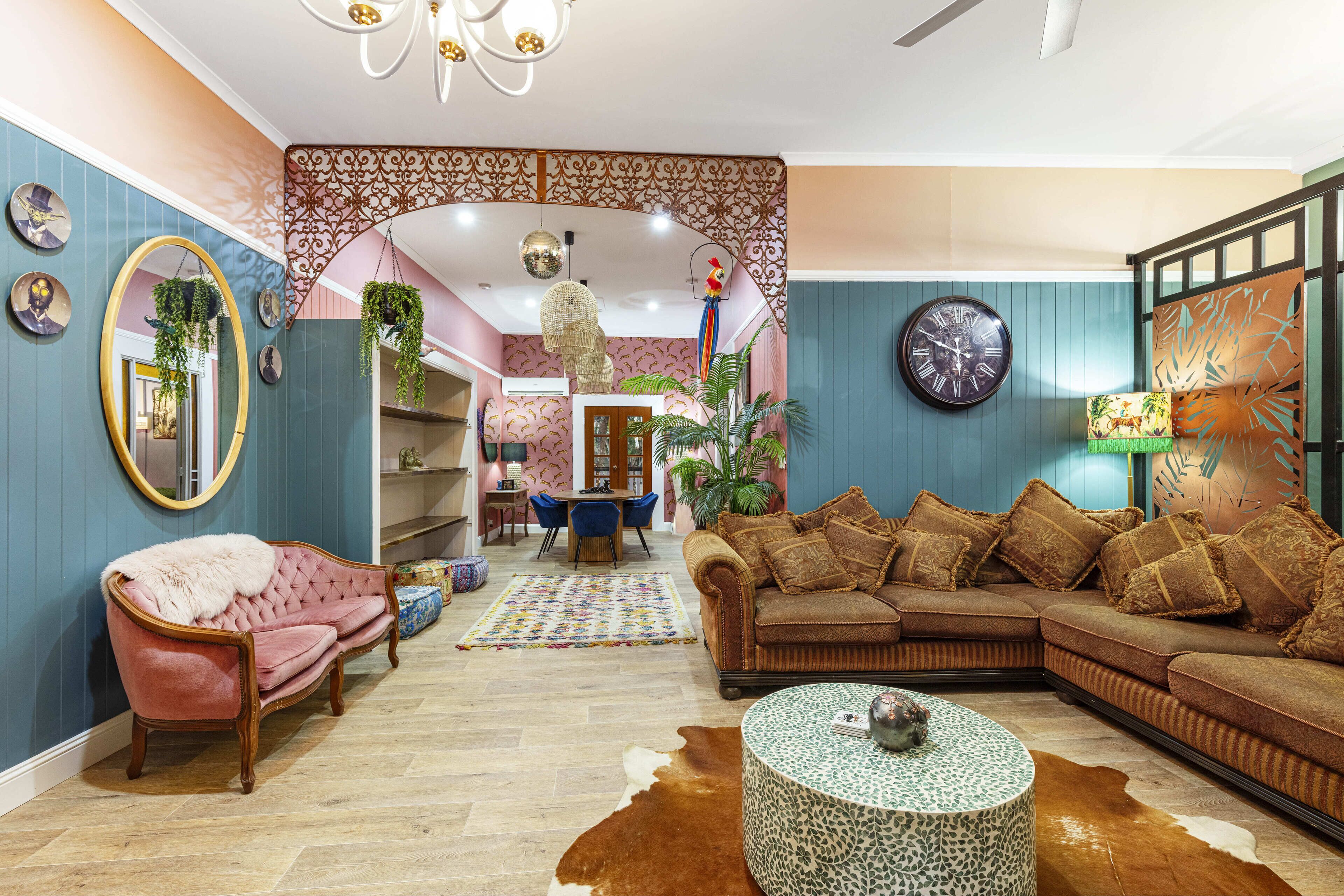 A cozy living room with a sofa, armchair, and coffee table, featuring a patterned rug and decorative items.