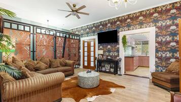 A living room with a sofa, a round coffee table, and a cowhide rug.