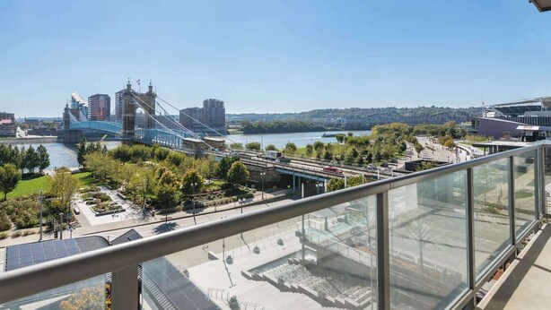 A high-rise building with a view of a bridge, river, and cityscape.