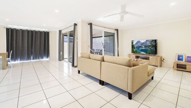 A modern living room with a beige sofa, a flat-screen TV, and a ceiling fan. - Bargara Haven
Welcome to your personal oasis: Coastal calm blends with style. (Bargara)