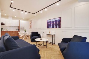 Ein modernes Wohnzimmer mit einer Sofagarnitur, einem Esstisch und einer Küche im Hintergrund.