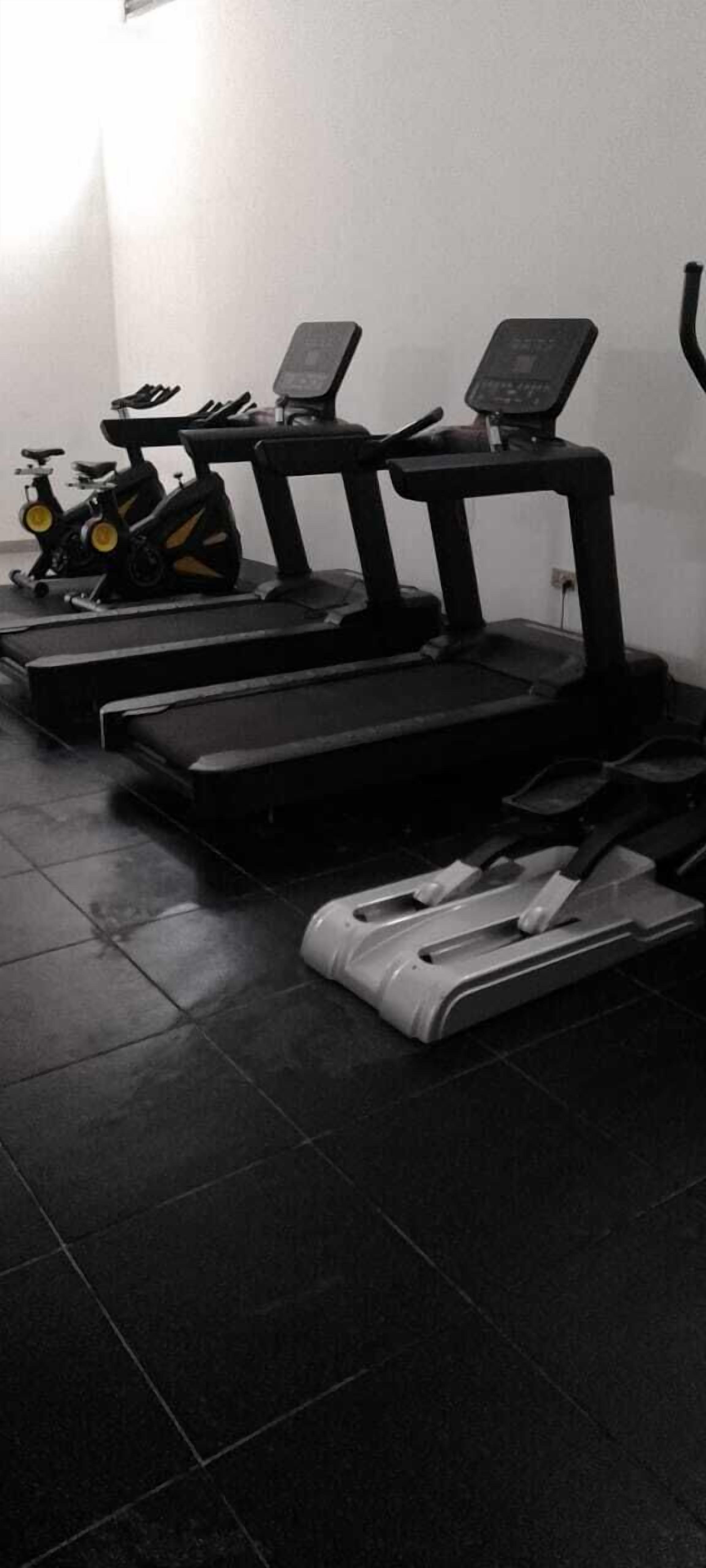 A gym with treadmills, stationary bikes, and a rowing machine.
