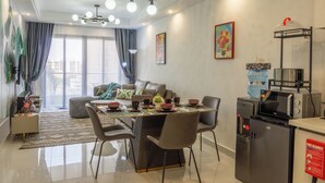 Una sala de estar moderna con comedor, kitchenette y vistas de la ciudad.