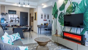 Una sala de estar moderna con chimenea, un comedor y una cocina al fondo.